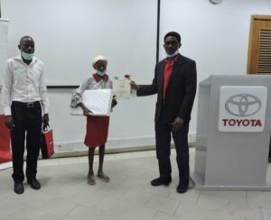 _Mr. B Onafowokan, presenting certificate to winner 3rd Position 12-15 years category Precious Ifeoluwa Aiyegbusi while her father looks on in admiration